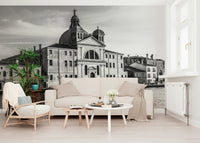 Venice Cityscape wallpaper mural of a black and white Venice church behind a beige sofa with rattan chair and palm