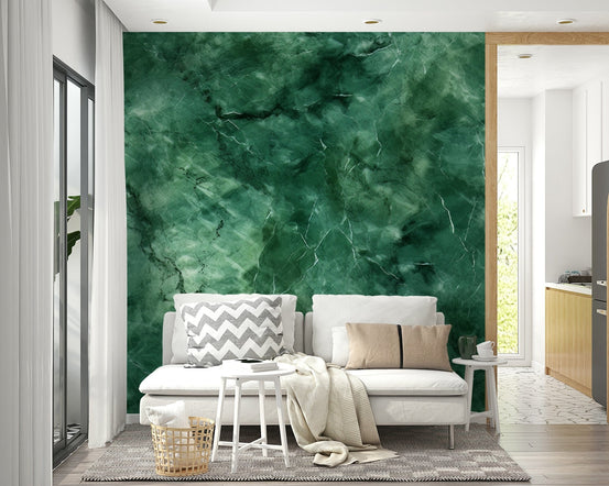 Verdant Veins wallpaper mural in emerald green marble behind a white sofa with chevron cushions in a living room
