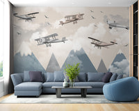 Vintage Aircraft wallpaper mural with biplanes and blue mountains behind a blue sectional sofa