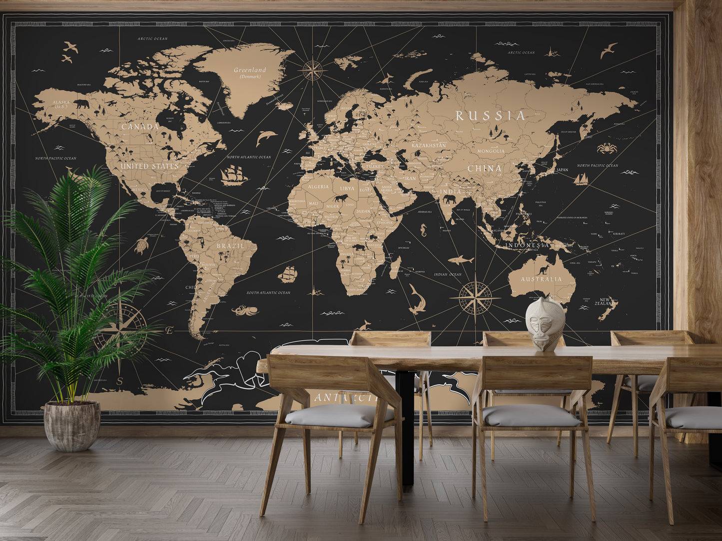 Vintage Black Golden World Map wallpaper mural in gold tones behind a wooden dining table and chairs with a palm plant