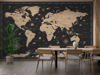 Vintage Black Golden World Map wallpaper mural in gold tones behind a wooden dining table and chairs with a palm plant