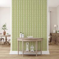 Vintage Bloom Rows wallpaper mural in an entryway behind a wood demilune console, green and cream daisy stripes