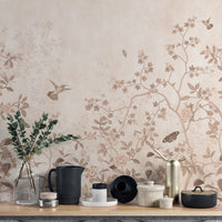 Vintage Chinoiserie Floral wallpaper mural in blush tones with hummingbirds and climbing blossoms behind a styled kitchen counter
