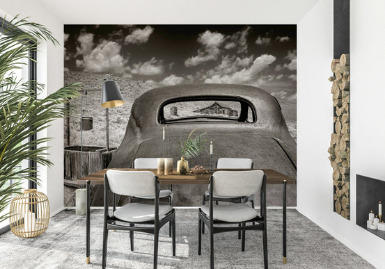 Ghost Town Relic wallpaper mural of a rusted vintage car in the desert behind a wood dining table and chairs