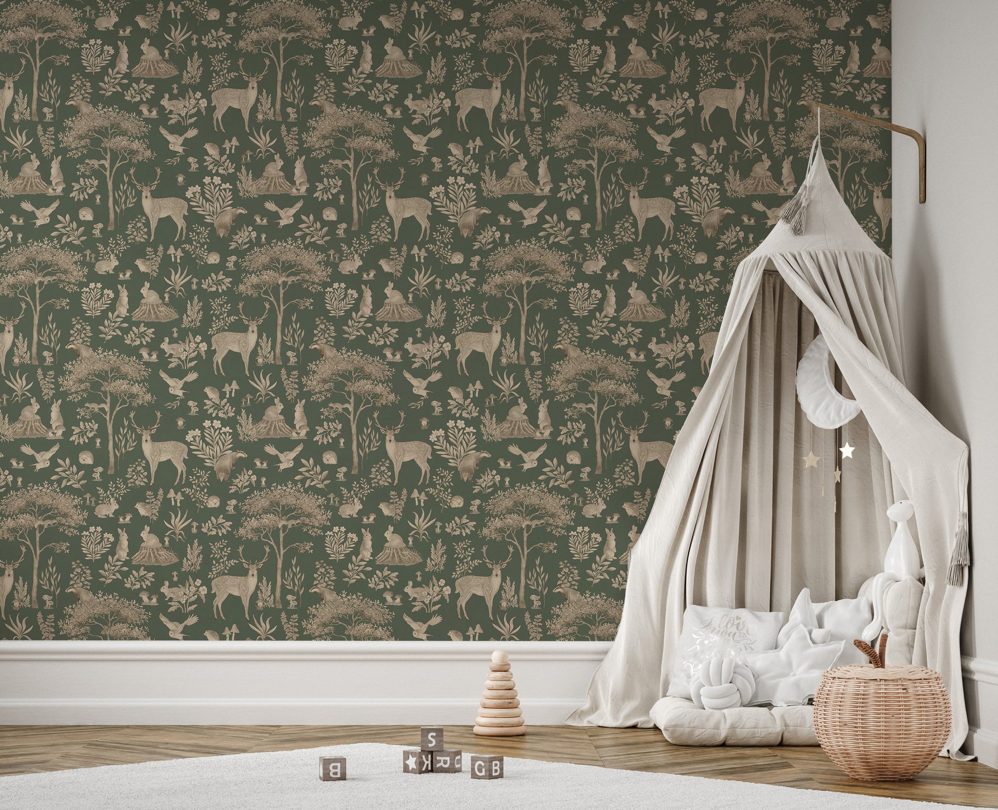 Vintage Green Wildlife wallpaper in a nursery corner with a beige canopy bed, rattan basket and stacking toy