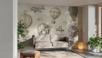 Vintage Hot Air Balloon Nursery wallpaper mural of balloons and planes behind a beige sofa and lantern lamp
