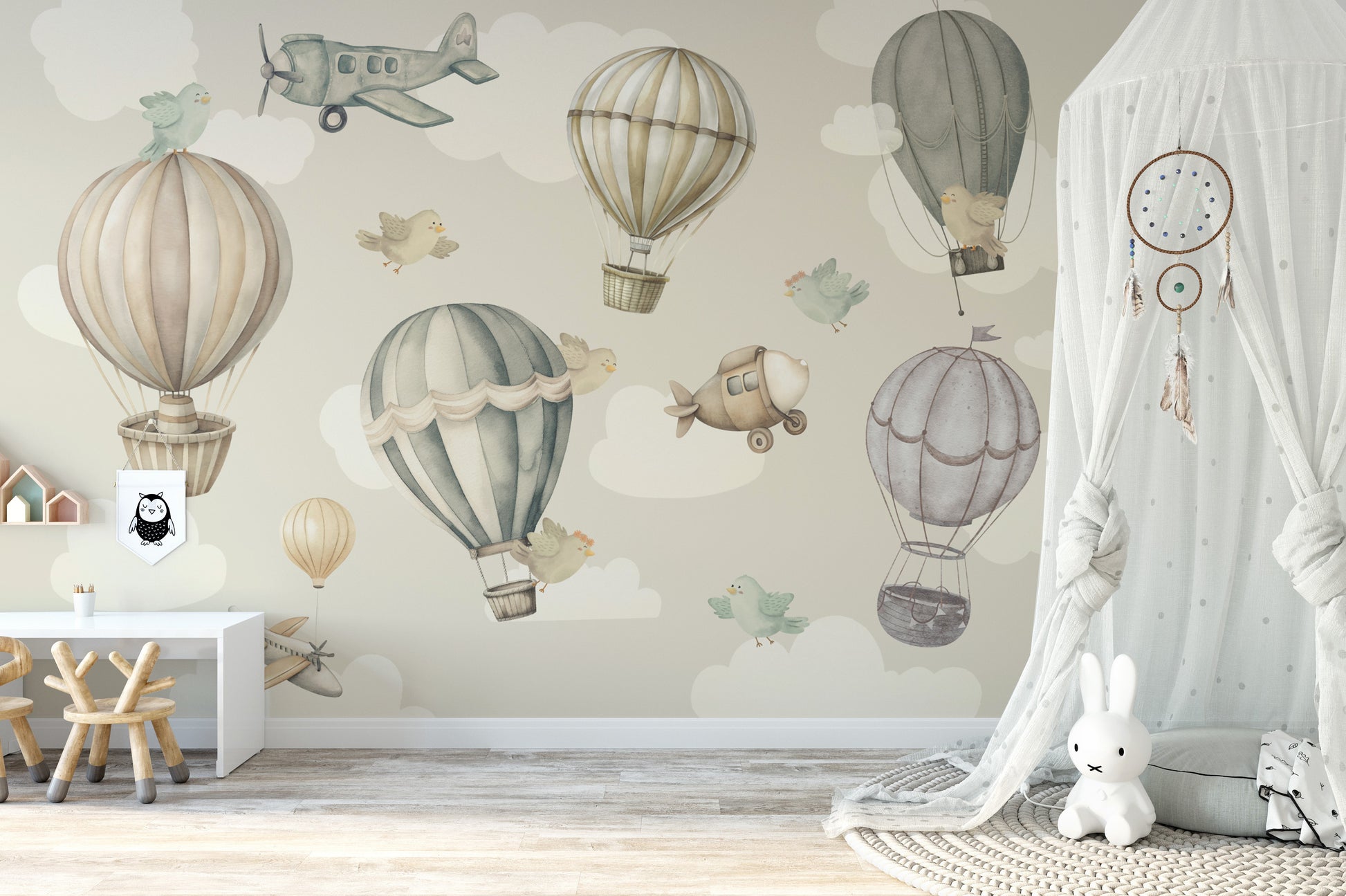 Vintage Hot Air Balloon Nursery wallpaper mural with balloons and a plane above a white kids desk and canopy