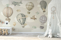 Vintage Hot Air Balloon Nursery wallpaper mural with balloons and a plane above a white kids desk and canopy