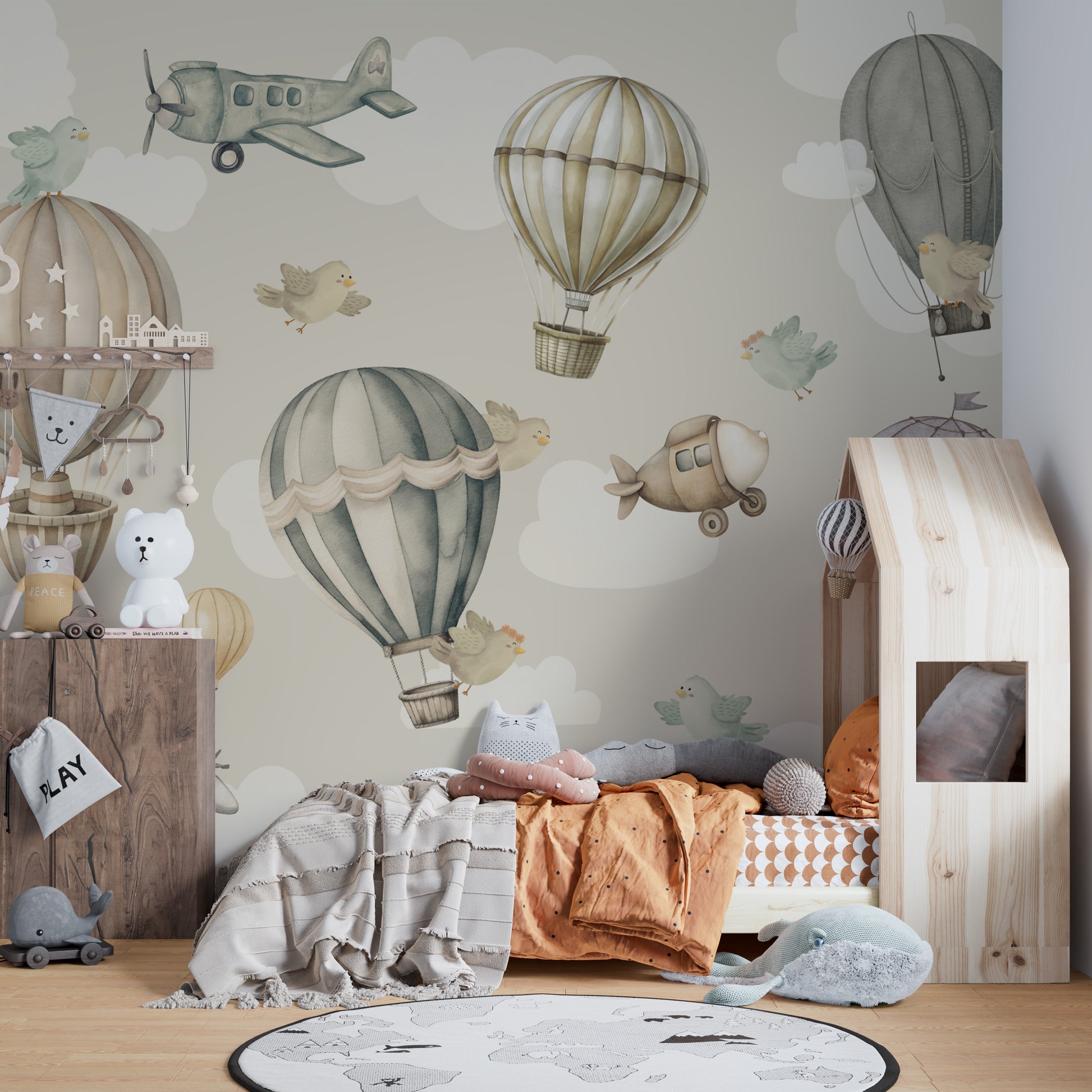 Vintage Hot Air Balloon Nursery wallpaper mural of balloons on sage sky beside a wooden house-frame kids bed