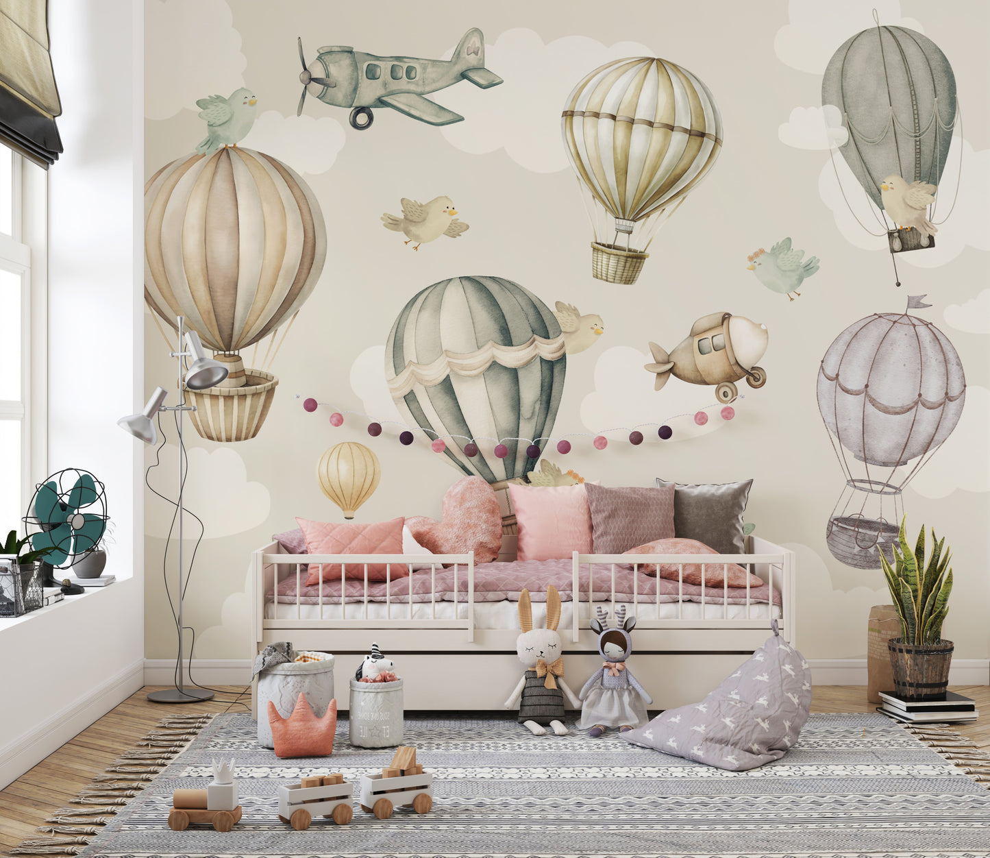 Vintage Hot Air Balloon Nursery wallpaper mural with balloons and birds over a white daybed and pink cushions