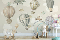 Vintage Hot Air Balloon Nursery wallpaper mural of pastel balloons and planes above a white toy pram and bunny
