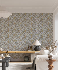 Vintage Foliage Golden and Gray wallpaper behind a white sofa and wooden bench in a bright living room