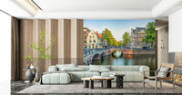 Visit Amsterdam wallpaper mural of a canal bridge behind a sage green sectional sofa by a wood-slat wall