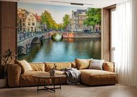 Visit Amsterdam wallpaper mural of a canal and stone bridge behind a tan sectional sofa in a living room