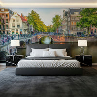 Visit Amsterdam wallpaper mural of a canal bridge and Dutch houses behind a gray bed with black marble nightstands