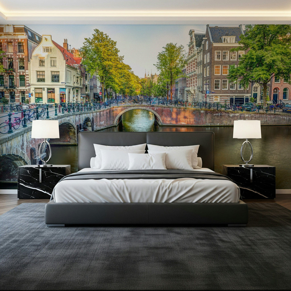 Visit Amsterdam wallpaper mural of a canal bridge and Dutch houses behind a gray bed with black marble nightstands
