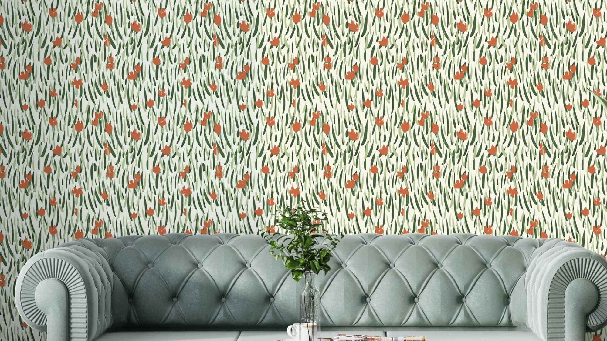 Wandering Blooms wallpaper with terracotta buds on green leaves behind a sage velvet tufted sofa in a living room