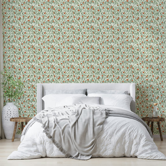 Wandering Blooms wallpaper in orange and green botanical strokes behind a white upholstered bed in a calm bedroom