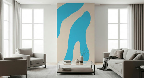 Water wall mural with flowing blue shapes on beige behind a gray sofa and armchair in a bright living room
