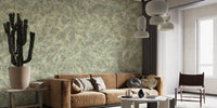 Watercolor Dancing Green Leaf wallpaper mural behind a tan sofa and a tall potted cactus in a living room