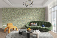 Watercolor Dancing Green Leaf wallpaper mural behind a curved green velvet sofa and orange chair in a living room