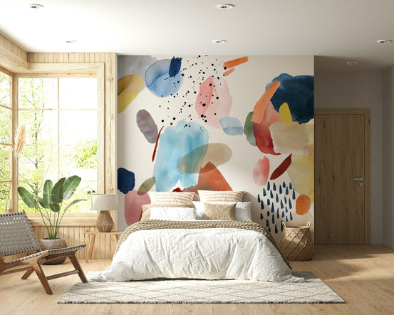 Watercolor Harmony wallpaper mural of abstract blue and coral blobs behind a white bed in a bright bedroom