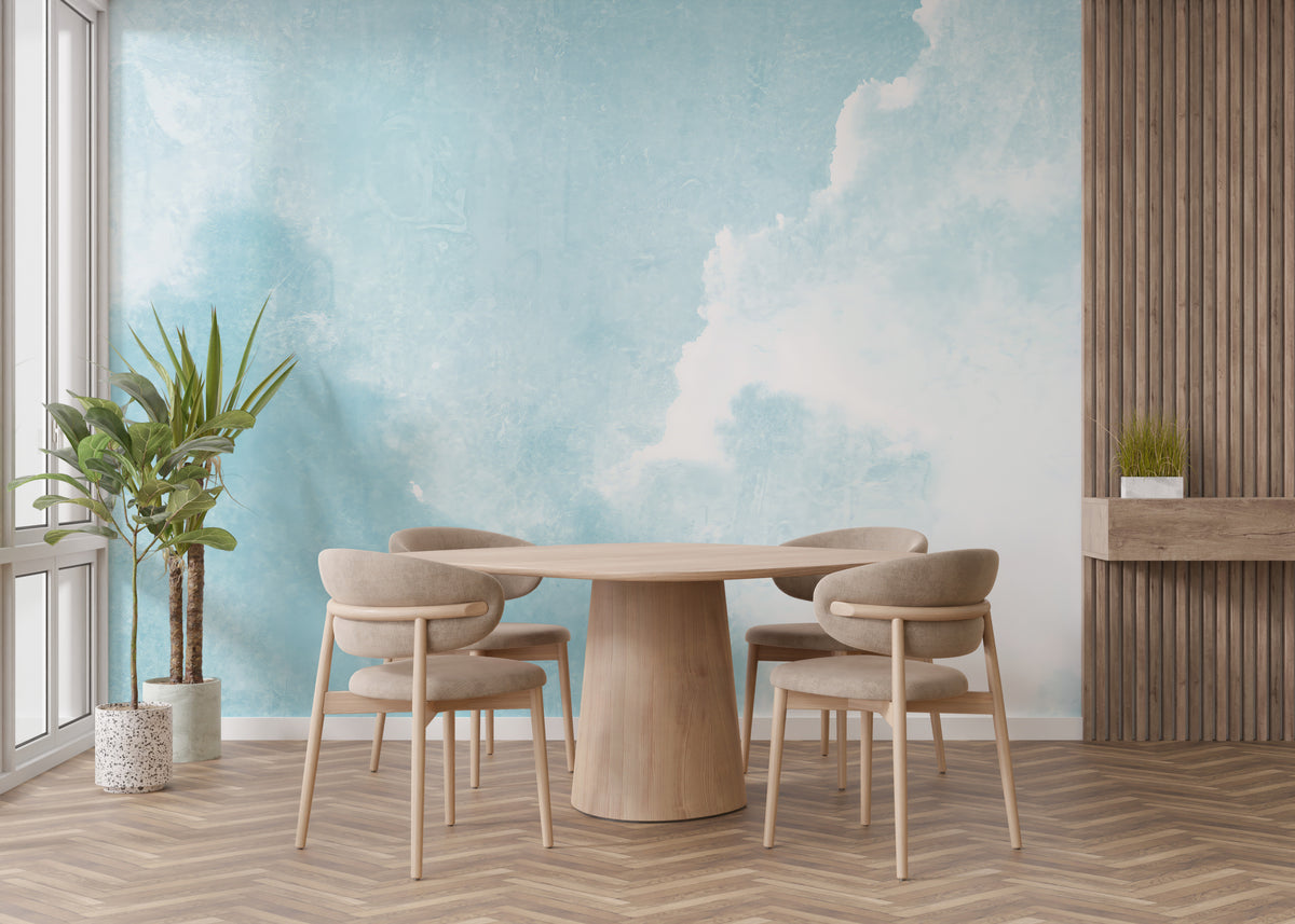 Watercolor Sky Clouds wallpaper mural of blue sky behind a round wood table and beige chairs in a dining room