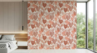 Soft pastel wallpaper mural filled with overlapping watercolor hearts in warm blush hues.