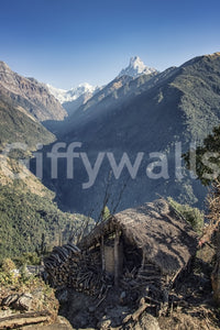Travel-inspired wall mural featuring a remote hut and breathtaking mountainous terrain.