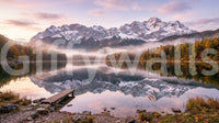 Rocky shoreline with fallen leaves in the foreground of the alpine wall mural
