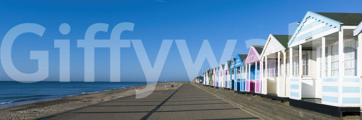 Deep ocean blue meets pale sand along the Colorful Beach Hut wall mural