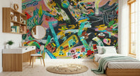 Urban Sprawl Symphony wallpaper mural with multicolor city art in a kids room with wood bed, green throw and round-mirror desk