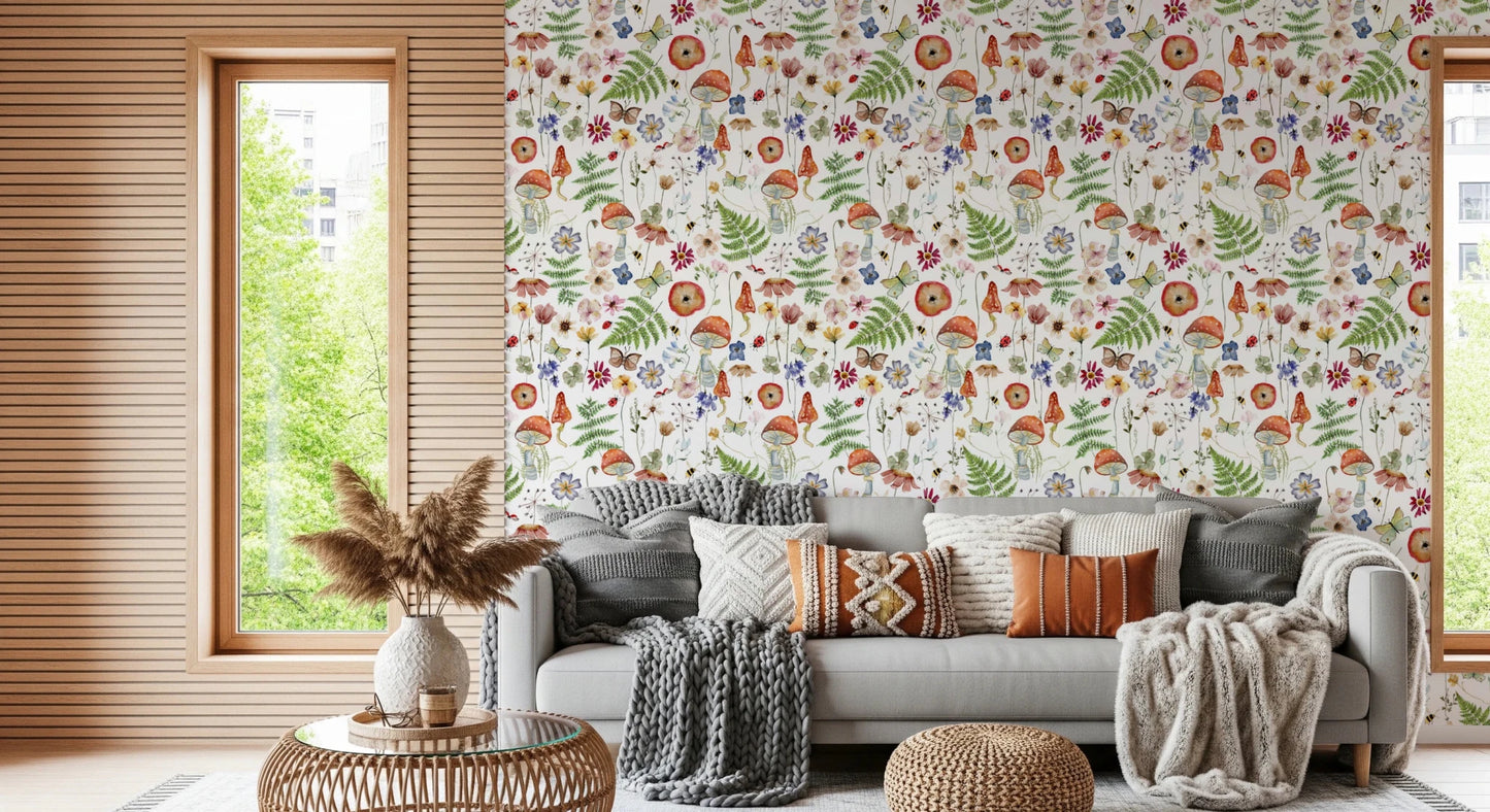 Whimsical Watercolor Meadow wallpaper mural in a living room with a grey sofa, boho cushions and woven poufs