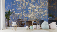 White Blossoms Against a Clear Blue Sky spring photography wall mural in a nursery with cloud pillows and toys along the floor
