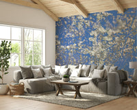 White Blossoms Against a Clear Blue Sky spring photography wall mural under a beamed ceiling behind a gray sectional in a living room