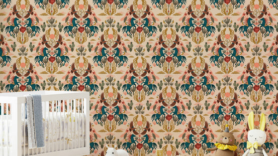 Wild West wallpaper with teal horses and cacti in a nursery with a white crib, grey blanket and plush toys