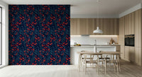 Winter Berries wallpaper in navy with red berries behind a light wood table and wishbone chairs in a kitchen