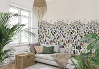 Winter Tree Wonderland wallpaper mural of stylized pines behind a grey sofa with plants and a wicker chest