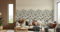 Winter Tree Wonderland wallpaper mural of stylized pines behind a white sofa with boho cushions in a lounge