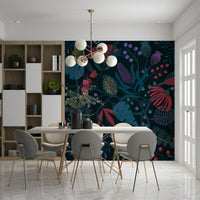 Wonderforest wallpaper mural in navy with pink blooms behind a white dining table and grey chairs
