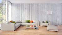 Wood Texture wallpaper in pale planks behind a cream sectional sofa and glass coffee table in a living room