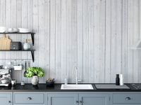 Wood Texture wallpaper in whitewashed planks above blue-grey kitchen cabinets with a sink