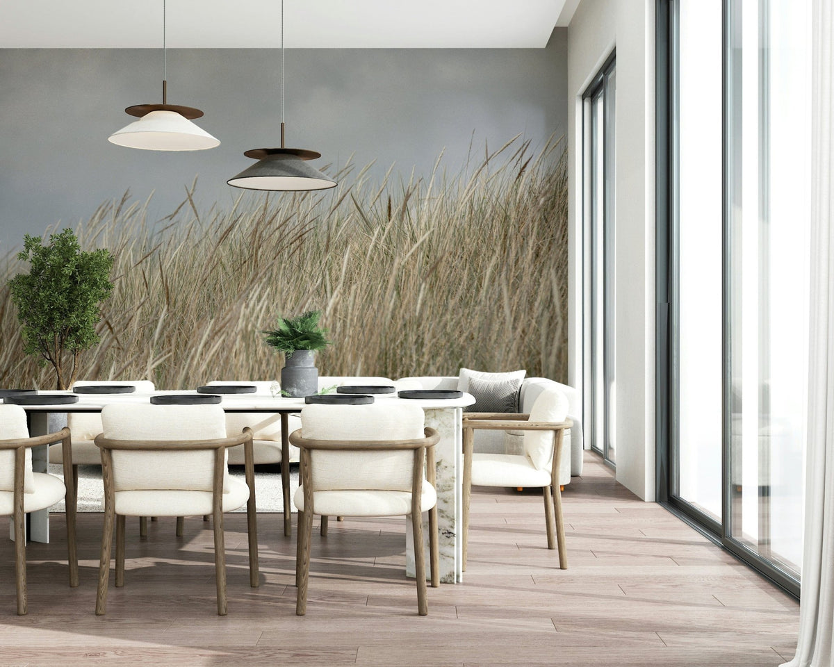 Woodland Dune Grass wallpaper showing beige wheat stalks swaying under grey sky.