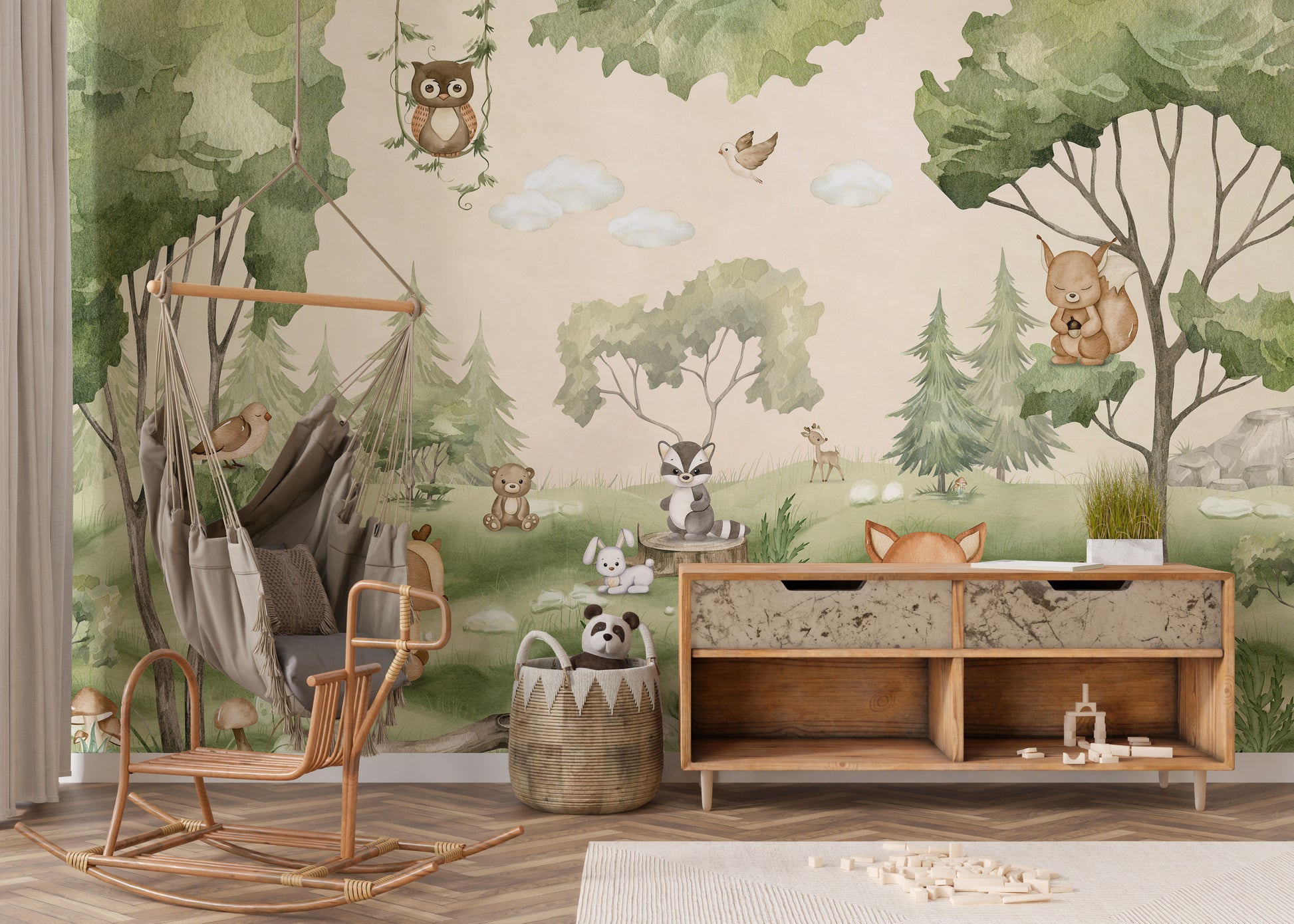 Woodland Joy Kids wallpaper mural with forest animals above a rattan swing chair and wood toy sideboard