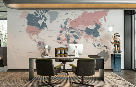 World Map Blush Pink and Indigo wallpaper mural behind a dark executive desk in a home office with armchairs