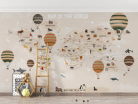 World Map Kids & Nursery wallpaper in beige behind a wooden ladder, teddy bear and toys in a playroom